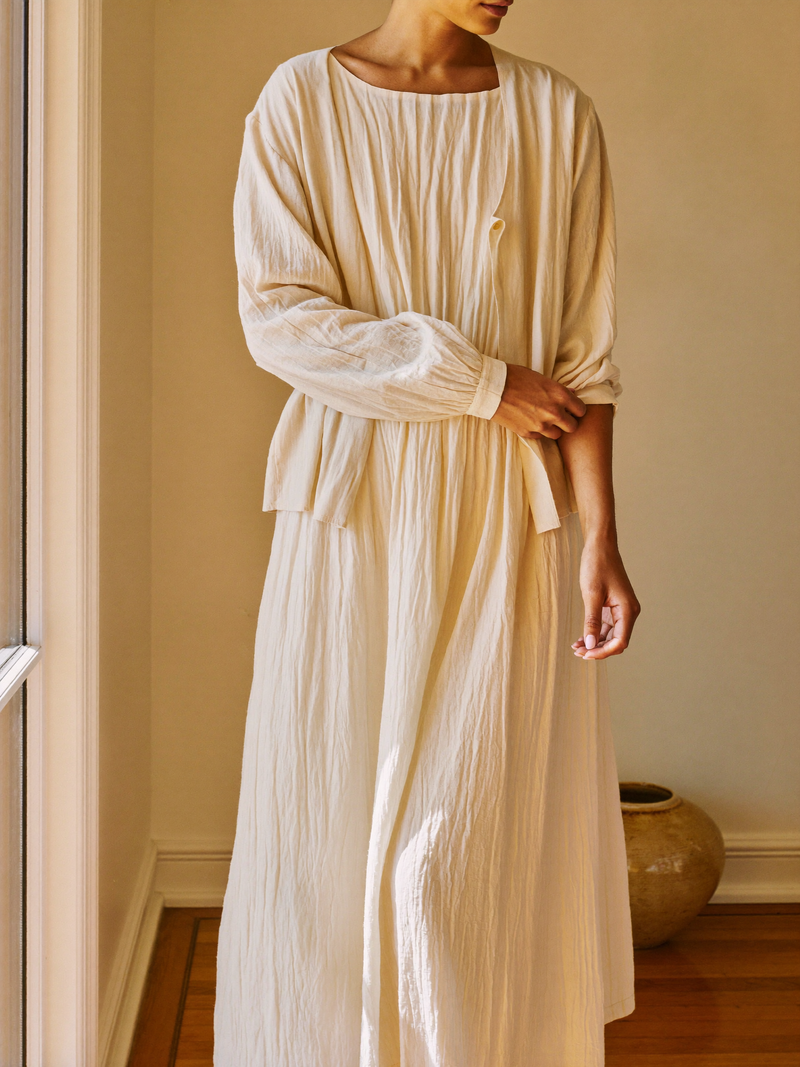 Flowing ecru midi dress in warm window light
