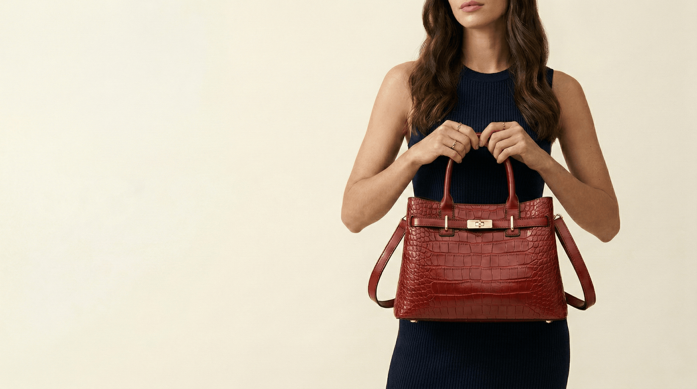 Woman holding a red handbag against a beige background