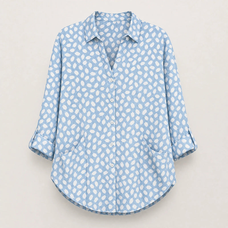 Sofaine Bella light blue blouse with white dot print, roll-tab sleeves and pockets, flat lay