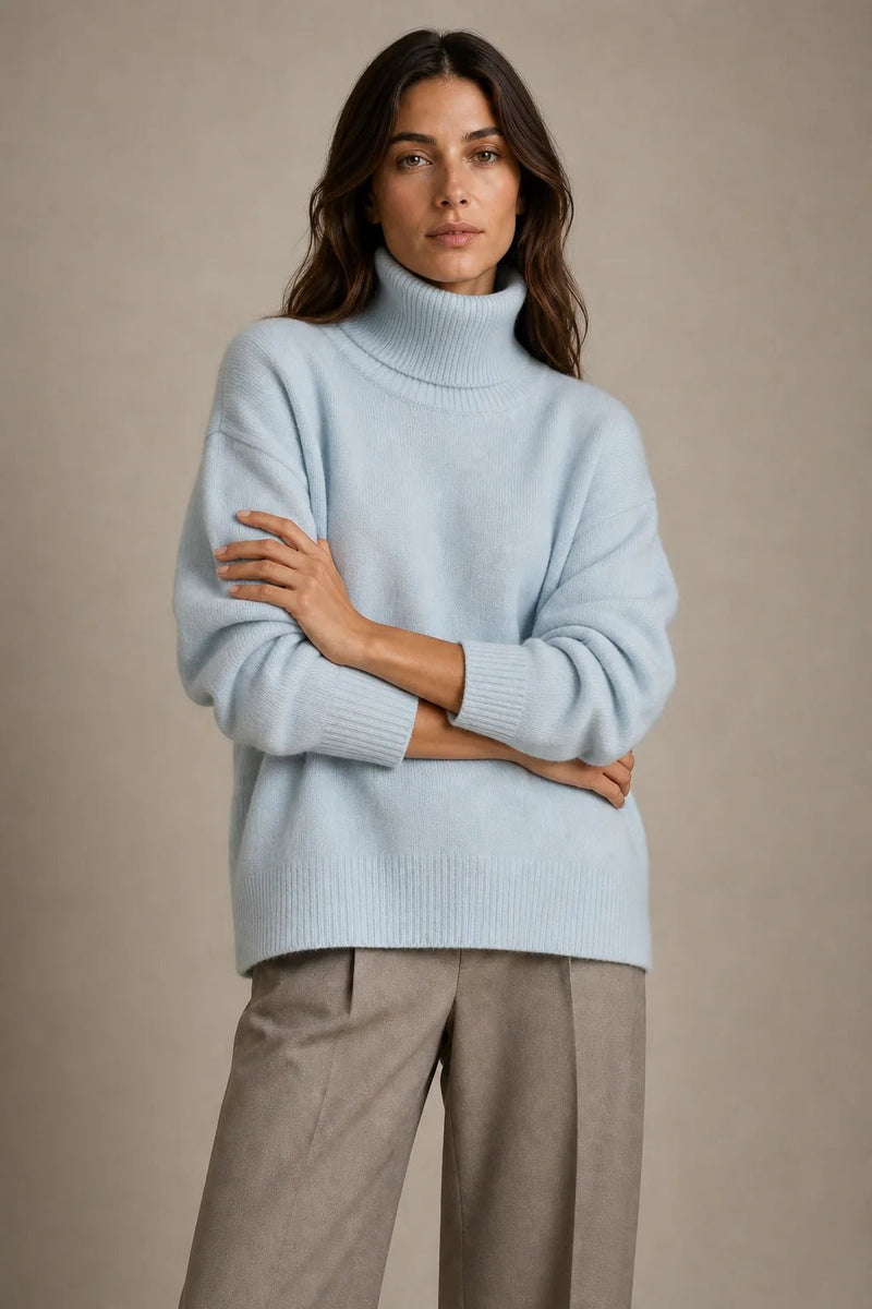 Sofaine Nova oversized knit turtleneck sweater in light blue, worn front view with arms crossed